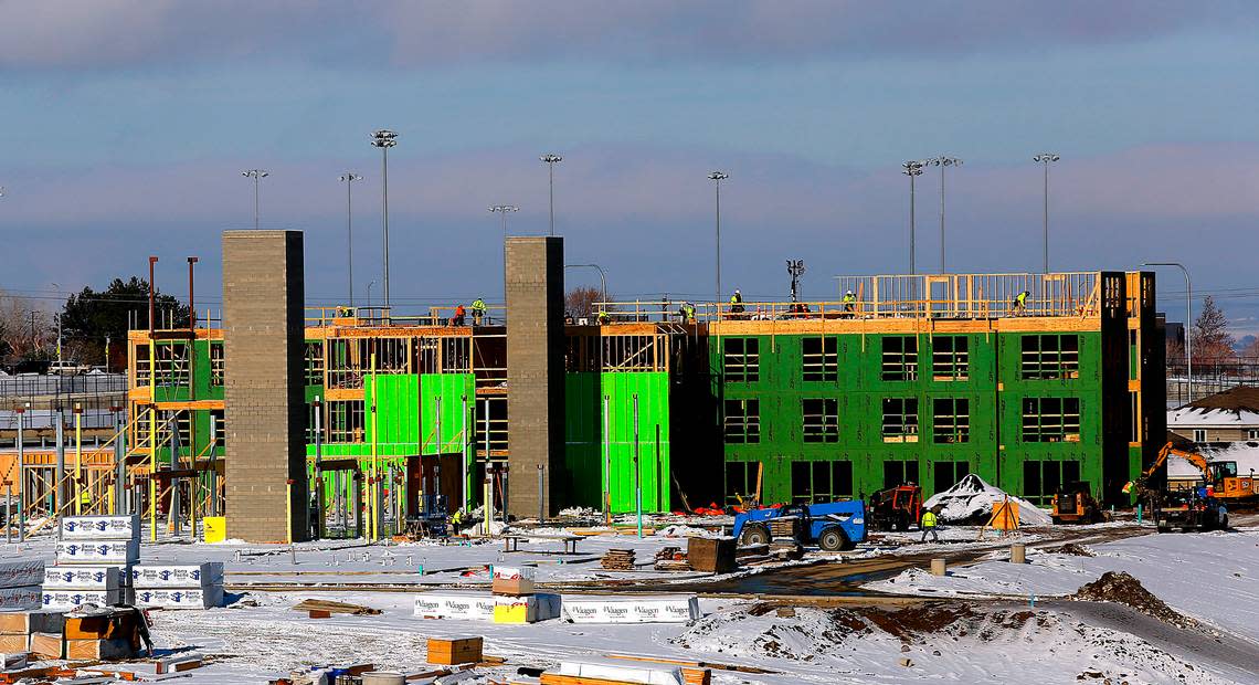 Two elevator shafts rise into the sky as construction workers build the first section of The Kennewick Retirement Residence, a four-story independent living retirement community.