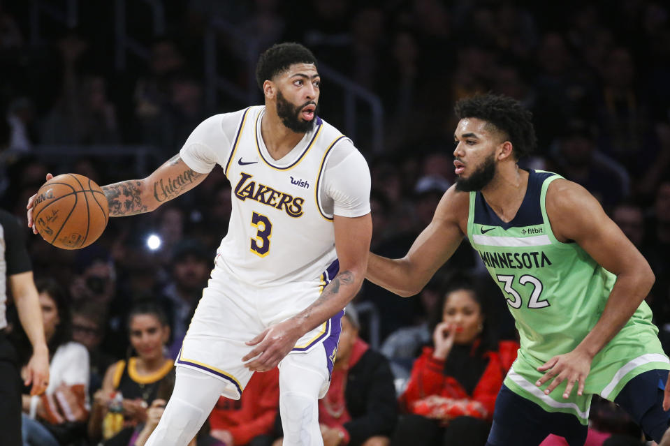Los Angeles Lakers' Anthony Davis (3) dribbles against Minnesota Timberwolves' Karl-Anthony Towns (32) during an NBA basketball game between Los Angeles Lakers and Minnesota Timberwolves, Sunday, Dec. 8, 2019, in Los Angeles. The Lakers won 142-125. (AP Photo/Ringo H.W. Chiu)