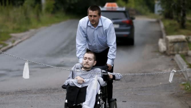 Valery Spiridonov volunteered to be the first person to undergo a head transplant, is assisted before a news conference in Russia, 2015. Photo: Maxim Zmeyev/REUTERS