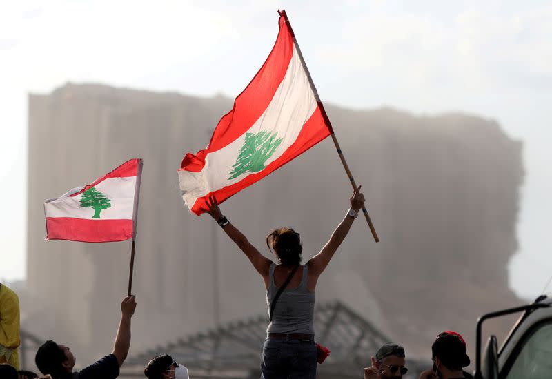 FILE PHOTO: Demonstrators wave Lebanese flags during protests near the site of a blast at Beirut's port area