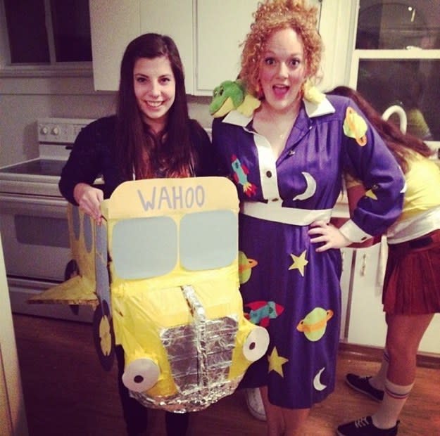 Woman dressed as a school bus and woman in a purple dress with a lizard on her shoulder