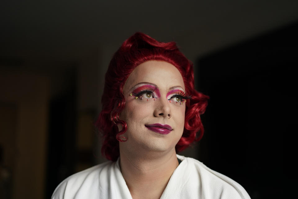 Drag queen Trixy Valentine, aka Jacob Kelley, in a red wig and finished makeup at the Washington Marriott Georgetown, in Washington, Wednesday, May 31, 2023. Trixy and twin Harpy Daniels, aka Joshua Kelley, are performing at the Rainbow Special Interest Group of NAFSA: Association of International Educators reception at Pitchers and a League of Her Own bar across town. Kelley is an LGBTQ+ activist and educator with a masters in human sexuality. (AP Photo/Carolyn Kaster)