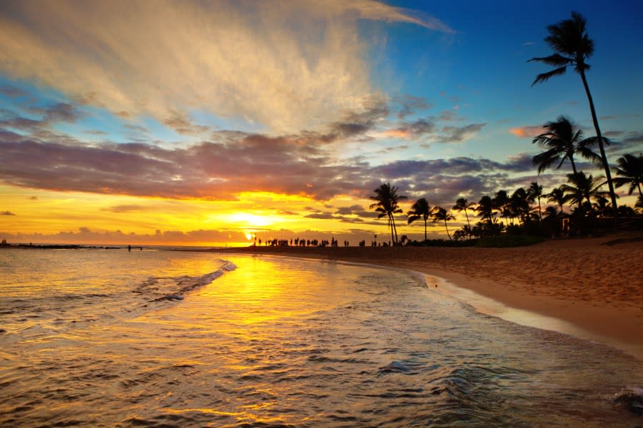 Numerous people, tourists and visitors enjoying the sunset at Poipu Beach in their tropical vacation. Poipu Beach, a popular vacation destination lined with resorts vacation condo rentals, restaurants and hotels on the south shore of Kauai, Hawaii. (Getty)