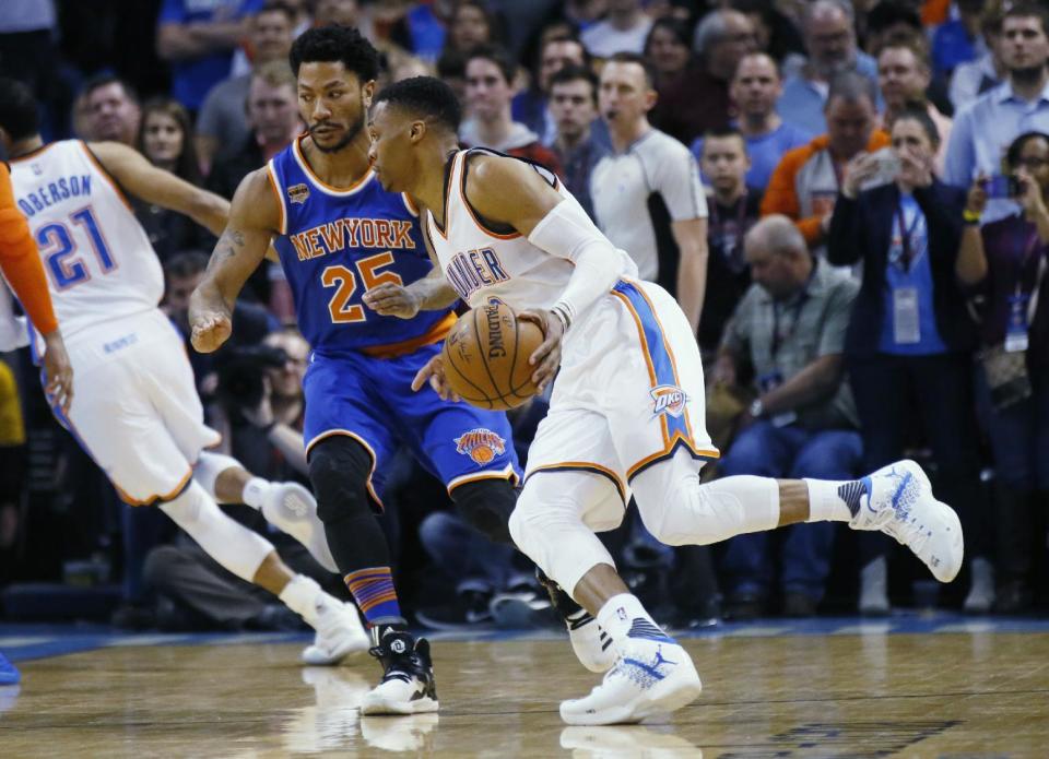 Oklahoma City Thunder guard Russell Westbrook, right, drives around New York Knicks guard Derrick Rose (25) during the first quarter of an NBA basketball game in Oklahoma City, Wednesday, Feb. 15, 2017. (AP Photo/Sue Ogrocki)