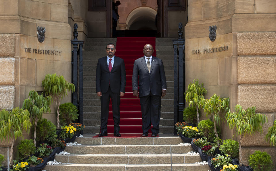 South African President Cyril Ramaphosa, right, with Ethiopia's Prime Minister Abiy Ahmed looks on during the singing of the national anthems by a guard of honor prior to their talks at the Union Building in Pretoria, South Africa, Sunday, Jan. 12, 2020. (AP Photo/Themba Hadebe)