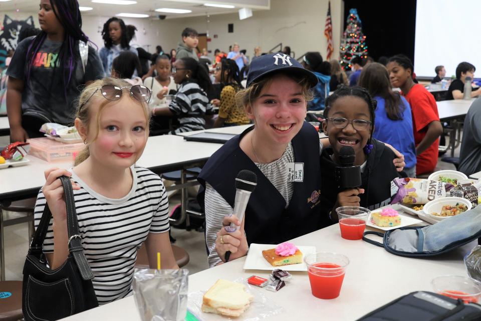 Sixth graders Aubrey Caparello, dressed as Taylor Swift, Gina Garcia, dressed as Kevin Jonas, and Makenzie Williams pose for a photo at a celebration for Taylor Swift's birthday at Swift Creek Middle School on Tuesday, Dec. 13, 2022.