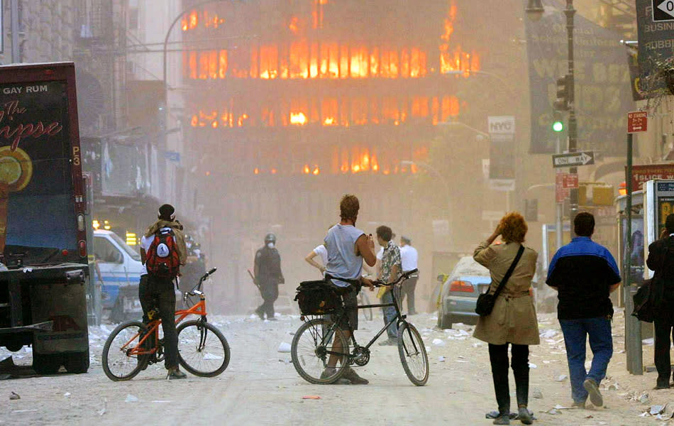 People walk in the street in the area where the World Trade Center buildings collapsed September 11, 2001 after two airplanes slammed into the twin towers in a suspected terrorist attack. (Photo by Mario Tama/Getty Images)