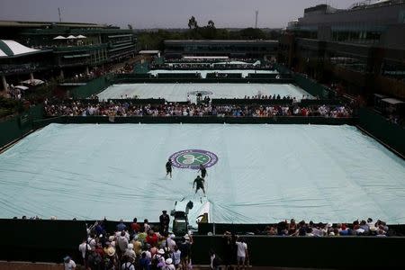 Rain covers on courts during a break in play at the Wimbledon Tennis Championships in London, July 2, 2015. REUTERS/Stefan Wermuth