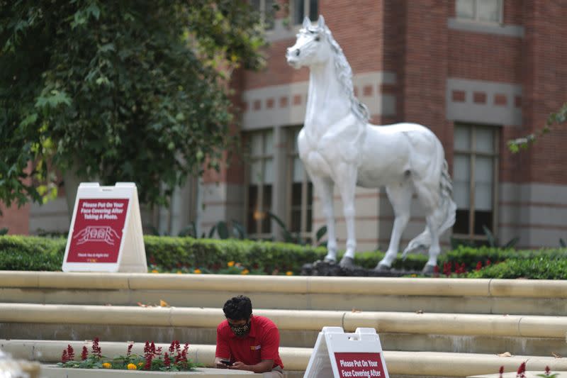 A man checks his phone on an empty University of Southern California (USC) campus, amid the outbreak of the coronavirus disease (COVID-19), in Los Angeles