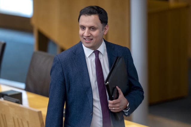 Anas Sarwar smiles as he enters the Holyrood chamber for First Minister's Questions