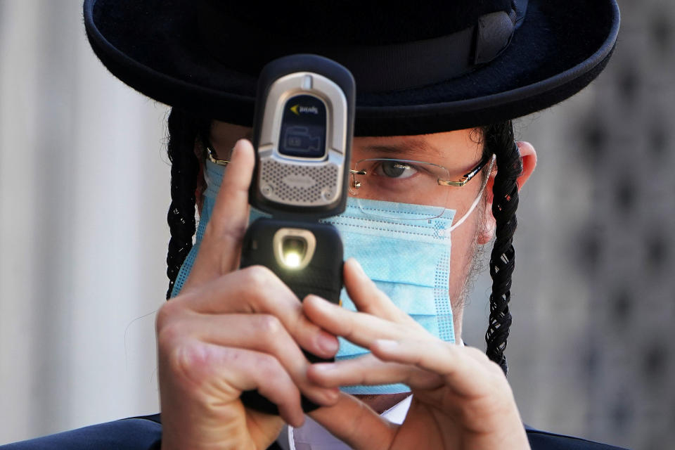 A Jewish man takes photos of a photographer while wearing a mask during the coronavirus disease (COVID-19) pandemic in the Borough Park section of the Brooklyn borough of New York City, New York, U.S., October 6, 2020. REUTERS/Carlo Allegri TPX IMAGES OF THE DAY