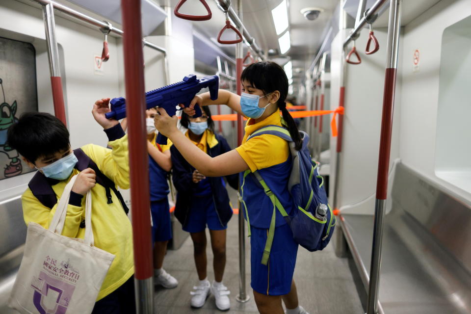 香港孩童在模型車廂內，使用模擬衝鋒槍。圖片來源：Reuters。