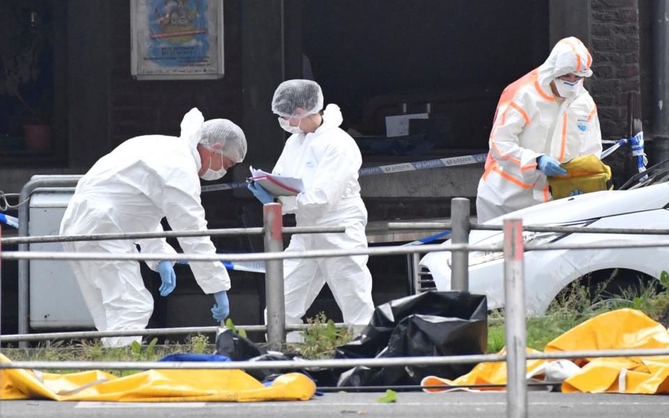 Forensic officers scour the scene for clues - AP