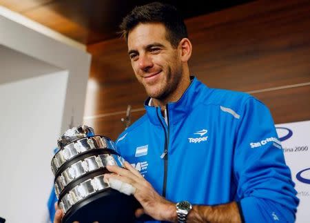 Juan Martin del Potro of Argentina's Davis Cup tennis team, holds a trophy after the team's arrival in Buenos Aires, Argentina, November 29, 2016. REUTERS/Agustin Marcarian