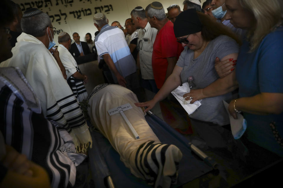 Mourners attend the funeral of Yigal Yehoshua, 56, at a cemetery in Hadid, central Israel, Tuesday, May 18, 2021. Yehoshua died of wounds sustained in when his car was pelted with rocks during Israeli Arab riots in the Israeli city of Lod on May 11. (AP Photo/Oded Balilty)