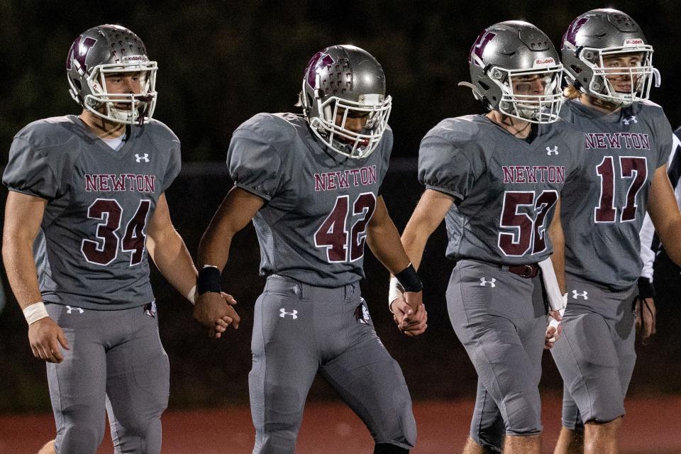 Newton hosts Ramsey in a high school football game on Friday October 14, 2022. (From left) N #34 Brayden Nolan, N #42 Thaylor Sibblies, N #52 Matthew McLean and N #17 Pasquale Festa walk onto the field. 