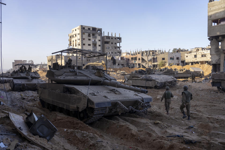 Soldados israelíes junto a un edificio destruido durante su campaña terrestre en la Franja de Gaza, el 8 de noviembre de 2023.(AP Foto/Ohad Zwigenberg)