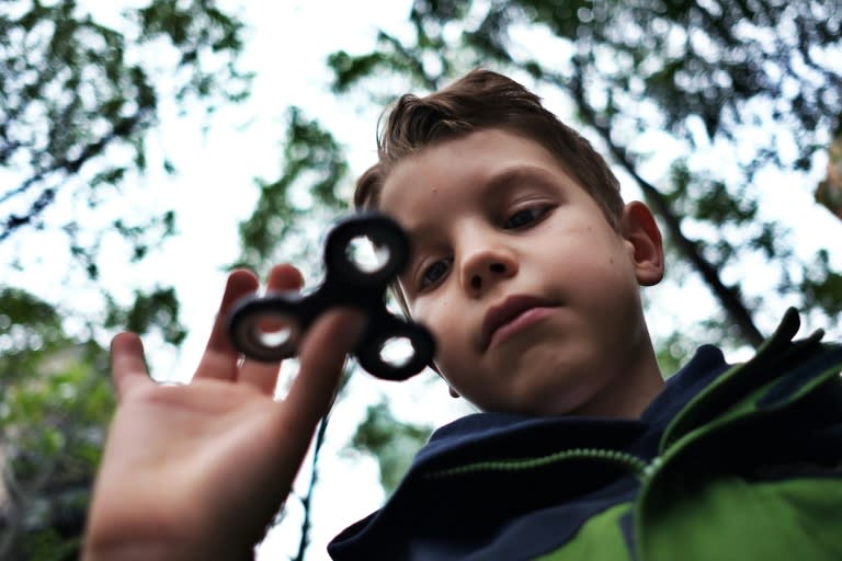 Eight-year-old Tom Wuestenberg plays with a fidget spinner in a park in New York on May 23, 2017