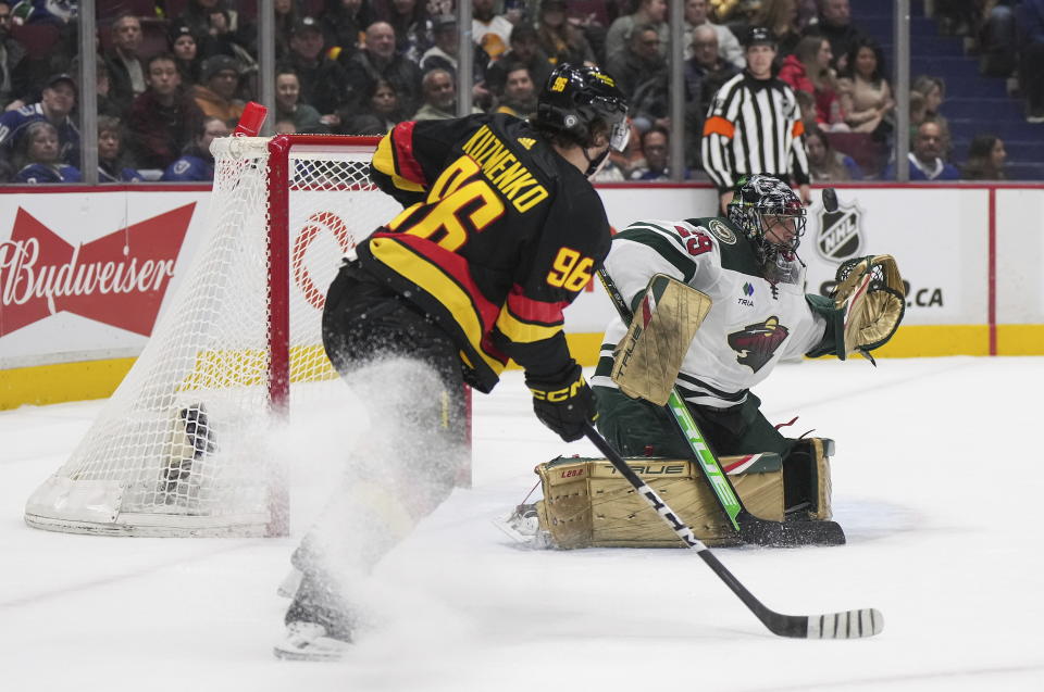 A shot goes wide of the net behind Minnesota Wild goalie Marc-Andre Fleury (29) as Vancouver Canucks' Andrei Kuzmenko (96) watches during the first period of an NHL hockey game Thursday, March 2, 2023, in Vancouver, British Columbia. (Darryl Dyck/The Canadian Press via AP)