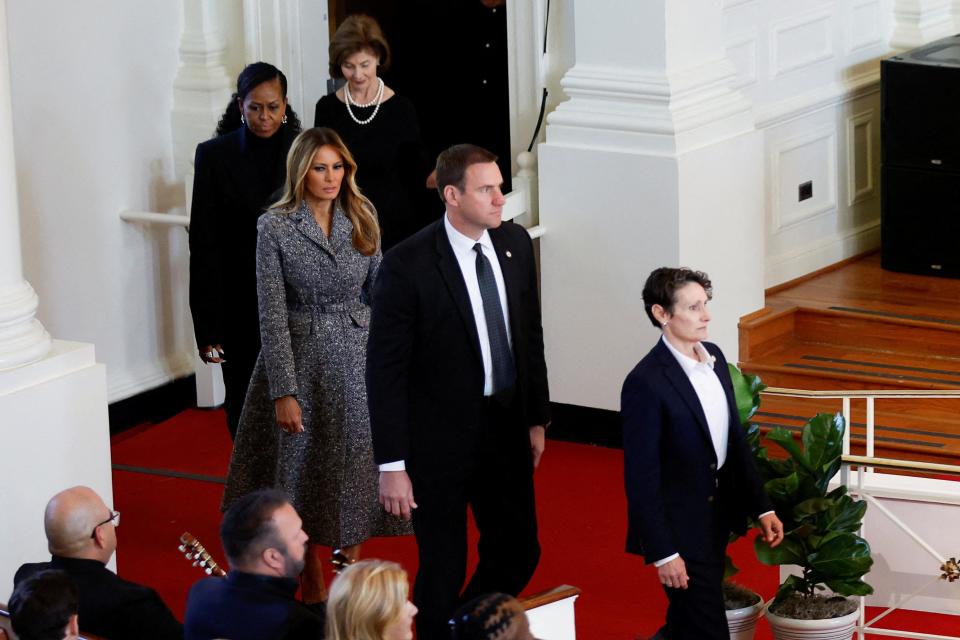 A photo of former U.S. first ladies Michelle Obama, Melania Trump, and Laura Bush attend a tribute service for former first lady Rosalynn Carter.