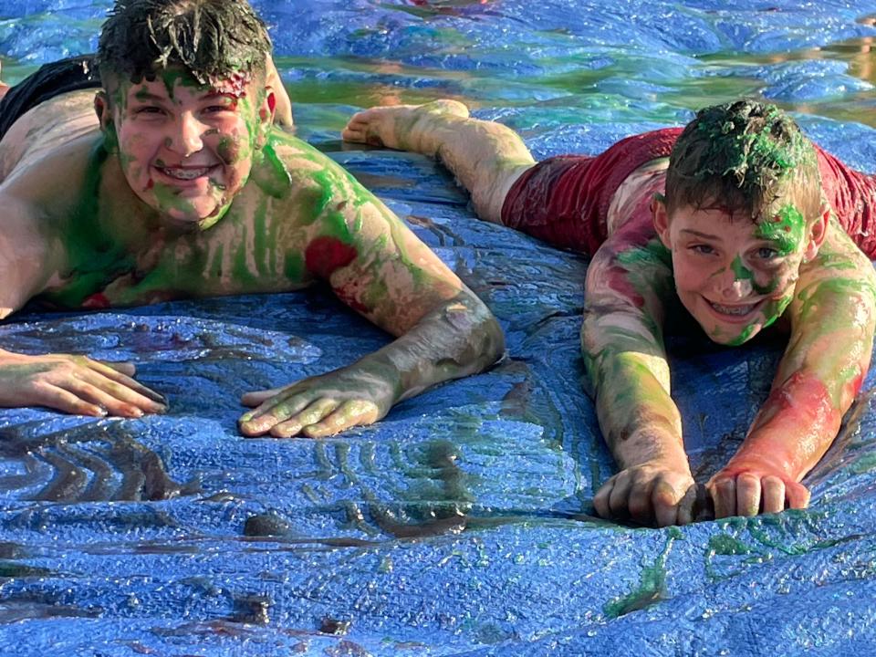 Owen Stanley, 13, and Simon Gibbs, 12, take a slide in the slippery slime at a slime battle at Concord United Methodist Church on Wednesday, June 23, 2022