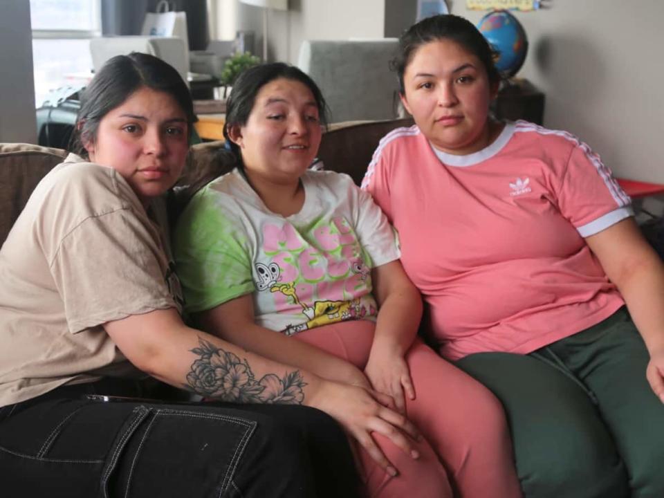 Sisters Valentina, Camila and Jesica Martinez Pardo, left to right, sit in their cousin's apartment in Hamilton on Tuesday. Their parents, Nelson Hernan Martinez Mora and Andrea Paola Pardo Rodriguez, are being detained by the Canada Border Services Agency and face deportation. (Samantha Beattie/CBC - image credit)