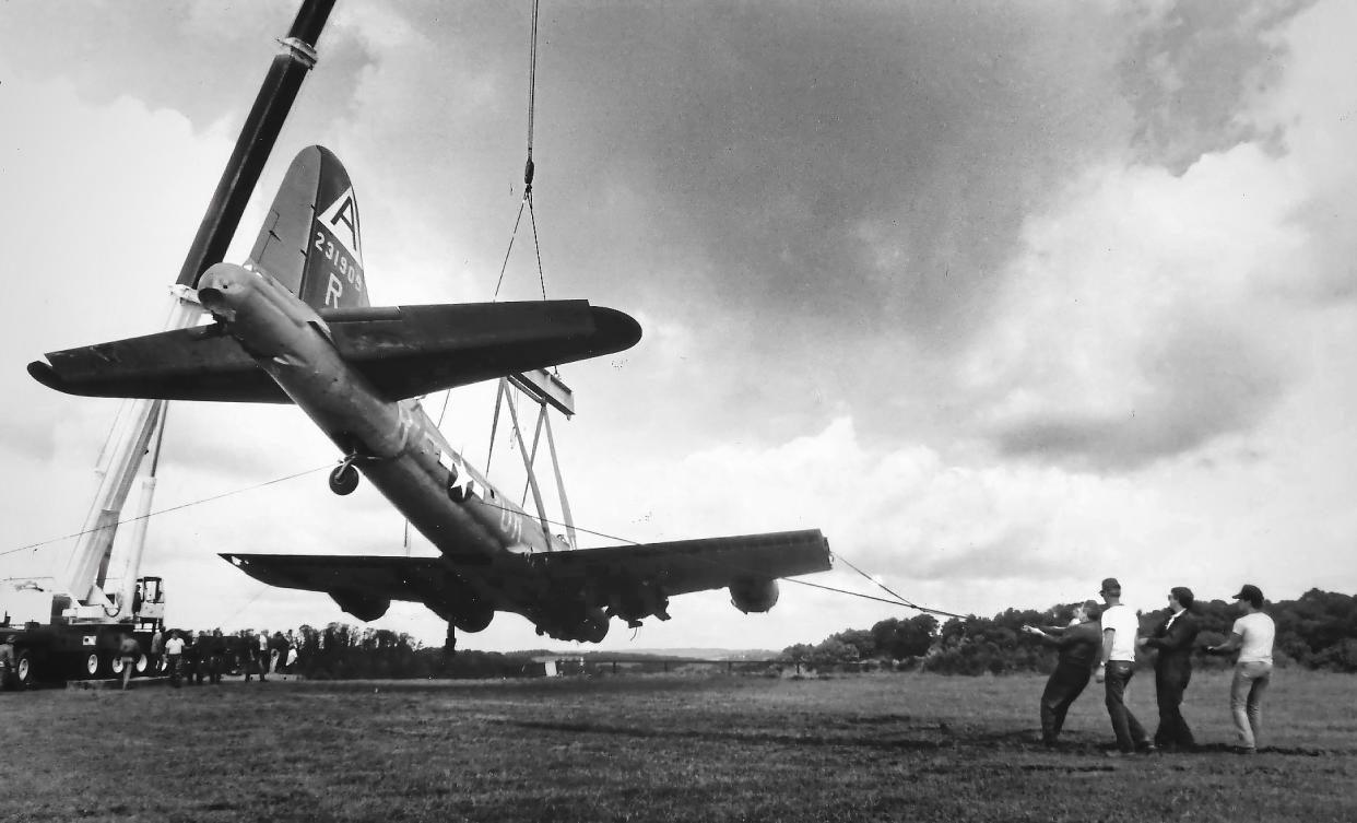 In this Aug. 29, 1987 photo, workers use a cane to lift a World War II-era B-17 plane from its crash site at the Beaver County Airport, in Beaver County, Pa. The same four-engine, propeller-driven B-17 bomber plane with more than a dozen people aboard crashed and burned at the Hartford County Bradley International Airport in Windsor Locks, Conn., after encountering mechanical trouble on takeoff Wednesday, Oct. 2, 2019, killing multiple people. (Susie Post/Pittsburgh Post-Gazette via AP)