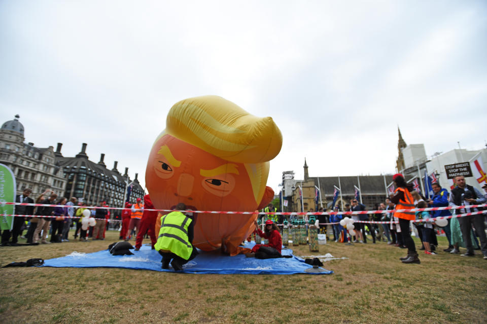 Members of the Baby Trump Balloon team set up the Donald Trump baby balloon in Parliament Square, London on the second day of the state visit to the UK by US President Donald Trump.