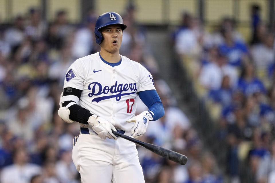 Los Angeles Dodgers' Shohei Ohtani reacts after stinging his hands on a foul ball during the fifth inning of a baseball game against the Kansas City Royals Saturday, June 15, 2024, in Los Angeles. (AP Photo/Mark J. Terrill)