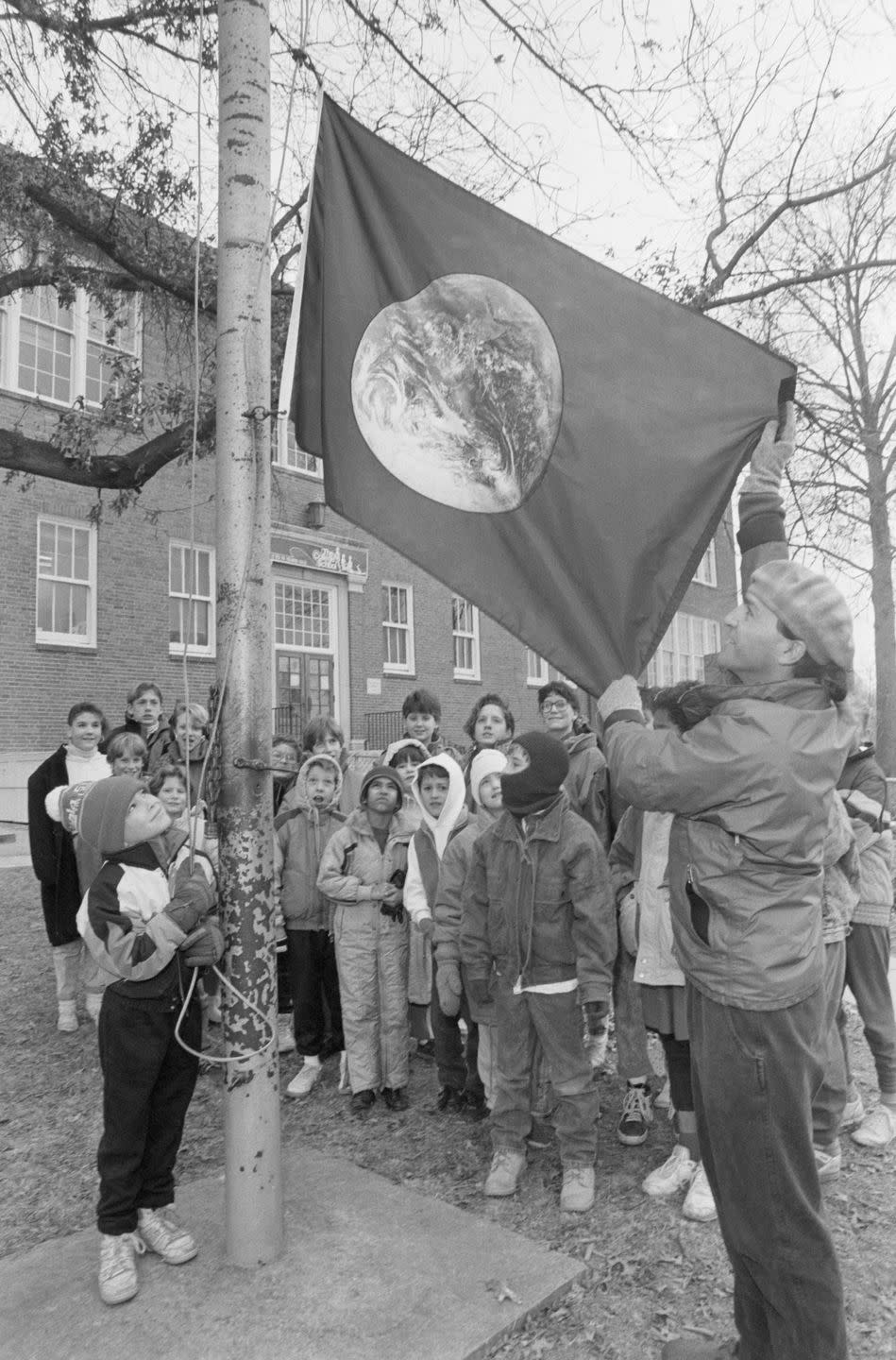 children watch as the earth day flag is raised