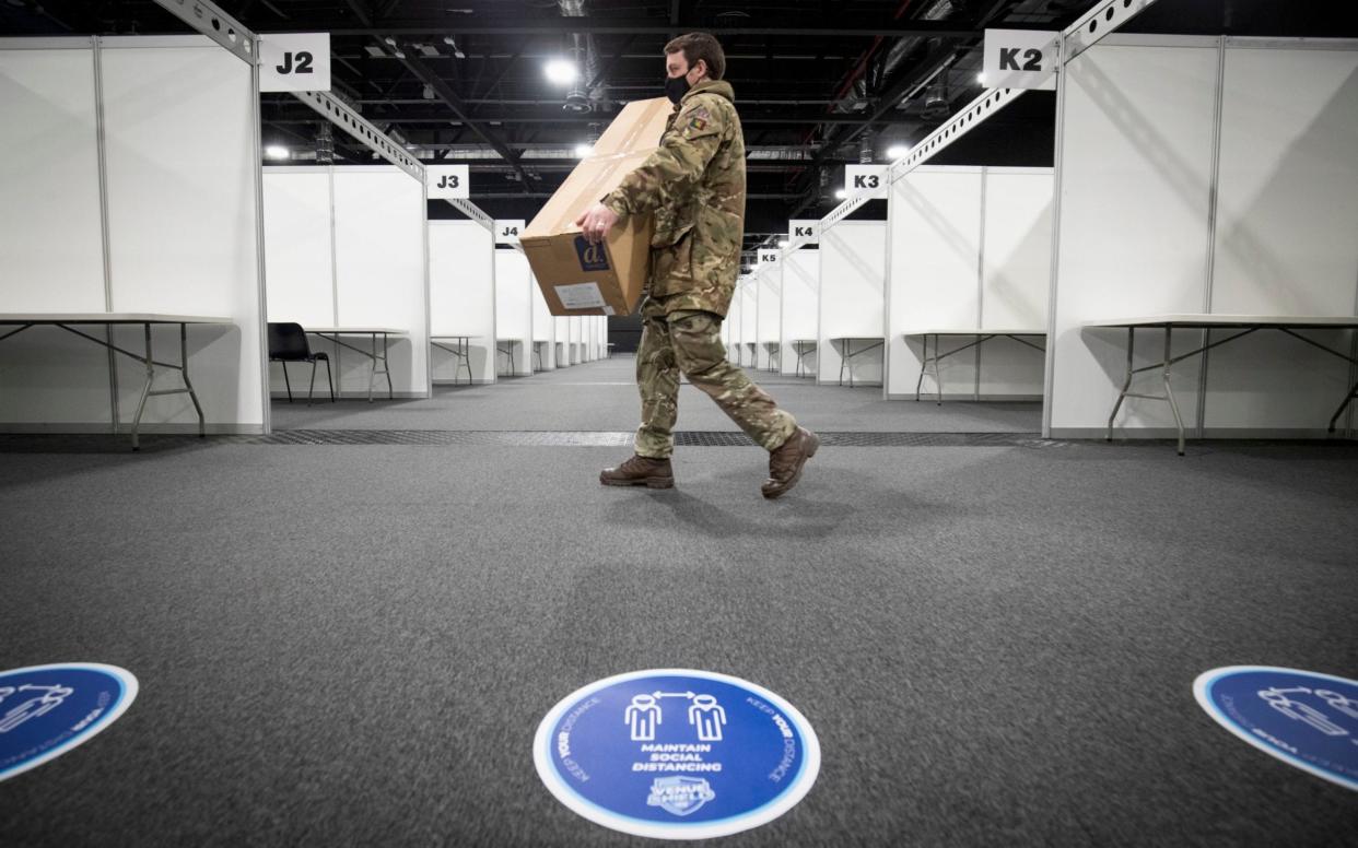 A member of the Royal Scots Dragoon Guard carries in supplies at the P&J Live mass vaccination centre in Aberdeen - PA