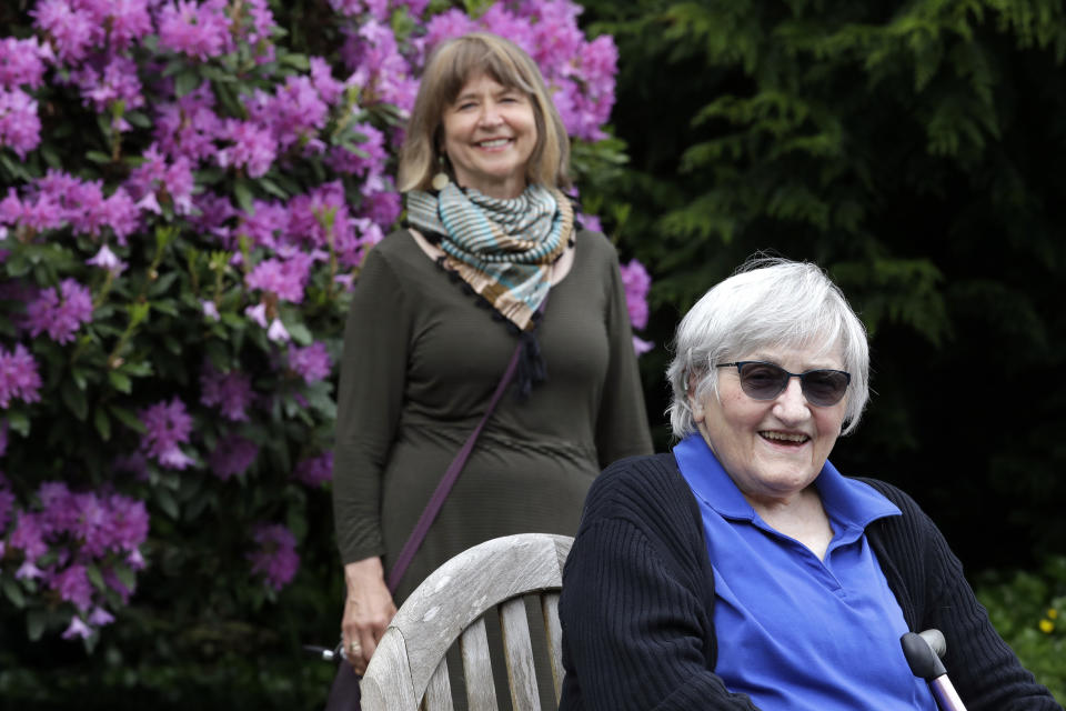 Jessie Cornwell, a resident of the Ida Culver House Ravenna, right, poses for a photo with the Rev. Jane Pauw, in Seattle on May 21, 2020. Cornwell tested positive for the coronavirus but never became ill, and may have been infectious when she shared a ride to Bible study with Pauw, who later got sick with COVID-19. (AP Photo/Elaine Thompson)