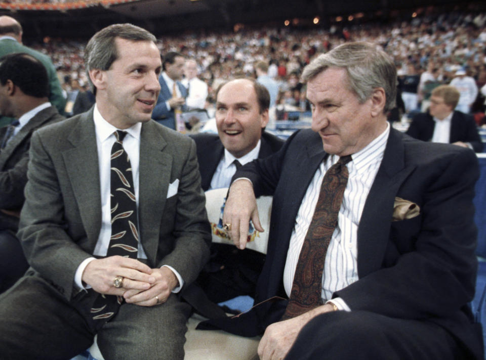 FILE - In this March 30, 1991, file photo, then-Kansas coach Roy Williams, left, and North Carolina coach Dean Smith talk before the start of the first NCAA national semifinal game in Indianapolis. North Carolina announced Thursday, April 1, 2021, that Hall of Fame basketball coach Roy Williams is retiring after a 33-year career that includes three national championships. (AP Photo/Bob Jordan, File)