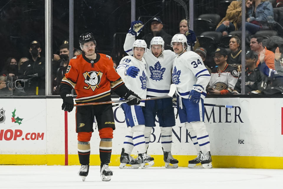 Toronto Maple Leafs' Auston Matthews, from right, Michael Bunting and Mitchell Marner celebrate a goal by Bunting as Anaheim Ducks' Sam Steel skates away during the second period of an NHL hockey game Sunday, Nov. 28, 2021, in Anaheim, Calif. (AP Photo/Jae C. Hong)