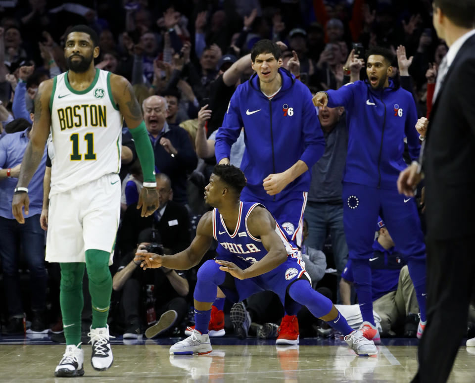 Philadelphia 76ers' Jimmy Butler, center, celebrates after scoring a basket against Boston Celtics' Kyrie Irving during the second half of an NBA basketball game Wednesday, March 20, 2019, in Philadelphia. Philadelphia won 118-115. (AP Photo/Matt Slocum)