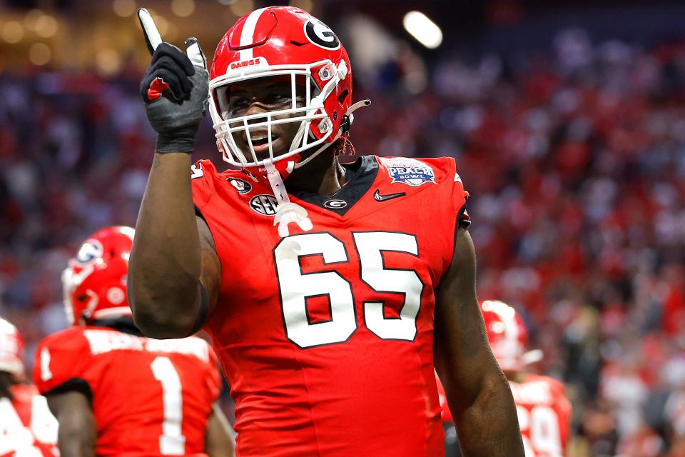 ATLANTA, GEORGIA - DECEMBER 31: Amarius Mims #65 of the Georgia Bulldogs reacts after a touchdown during the second quarter against the Ohio State Buckeyes in the Chick-fil-A Peach Bowl at Mercedes-Benz Stadium on December 31, 2022 in Atlanta, Georgia.