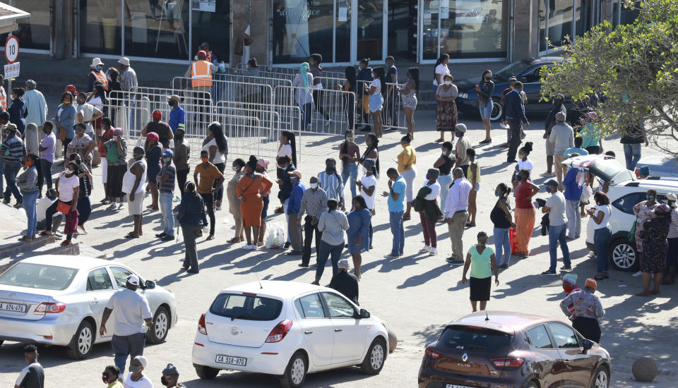 In this photo taken Tuesday, May 19, 2020, customers queue at a mall without practicing social distancing at a mall in Khayelitsha in Cape Town South Africa. With dramatically increased community transmission, Cape Town has become the center of the COVID-19 outbreak in South Africa and the entire continent. (AP Photo/Nardus Engelbrecht)