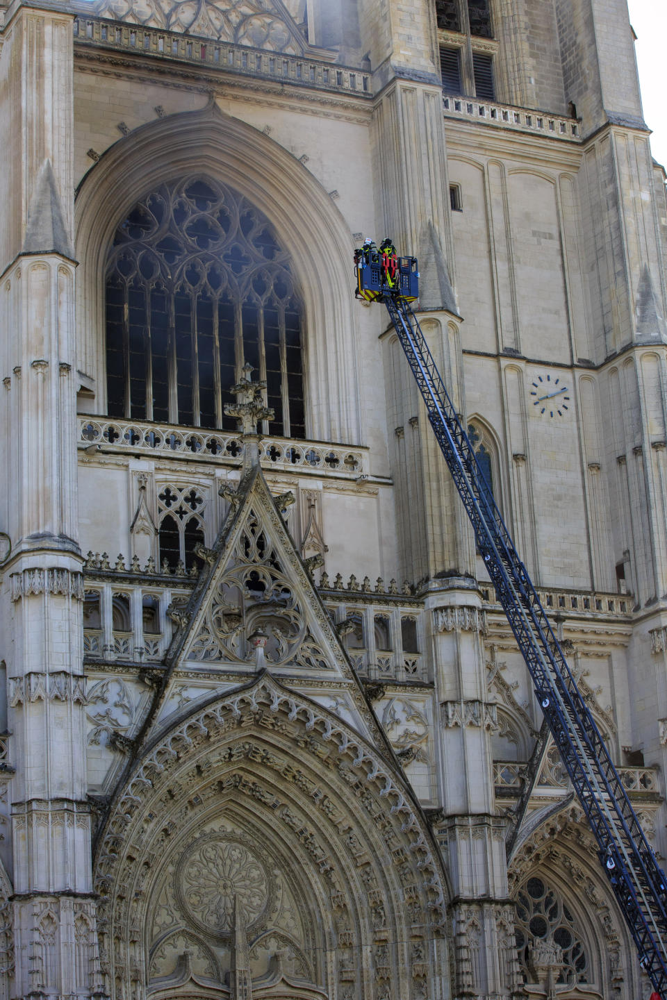 Fire fighters brigade work to extinguish the blaze at the Gothic St. Peter and St. Paul Cathedral, in Nantes, western France, Saturday, July 18, 2020. The fire broke, shattering stained glass windows and sending black smoke spewing from between its two towers of the 15th century, which also suffered a serious fire in 1972. The fire is bringing back memories of the devastating blaze in Notre Dame Cathedral in Paris last year that destroyed its roof and collapsed its spire and threatened to topple the medieval monument. (AP Photo/Laetitia Notarianni)