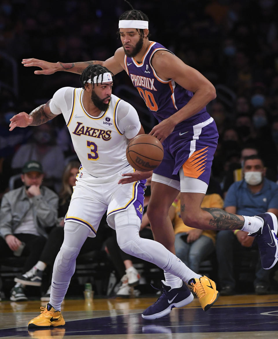 Los Angeles Lakers forward Anthony Davis (3) and Phoenix Suns center JaVale McGee (0) battle for the ball during the first half of a preseason NBA basketball game in Los Angeles, Sunday, Oct. 10, 2021. (AP Photo/John McCoy)