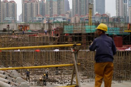 Labourers work at a construction site on the Bund in front of the financial district of Pudong in Shanghai, China October 19, 2016. REUTERS/Aly Song