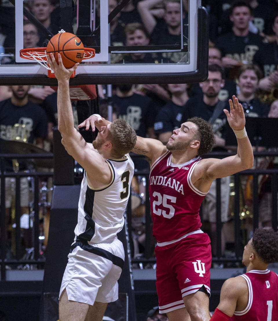 Purdue forward Caleb Furst (3) is fouled by Indiana forward Race Thompson (25) as Thompson attempts to block a shot during the first half of an NCAA college basketball game, Saturday, March 5, 2022, in West Lafayette, Ind. (AP Photo/Doug McSchooler)
