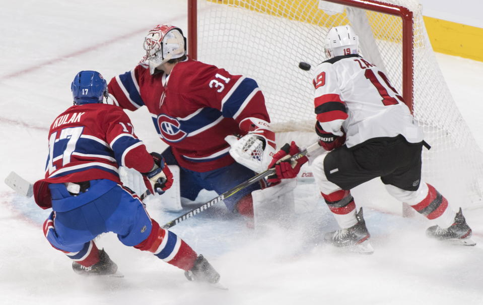 New Jersey Devils' Travis Zajac (19) scores against Montreal Canadiens goaltender Carey Price as Canadiens' Brett Kulak (17) defends during first-period NHL hockey game action in Montreal, Thursday, Nov. 28, 2019. (Graham Hughes/The Canadian Press via AP)