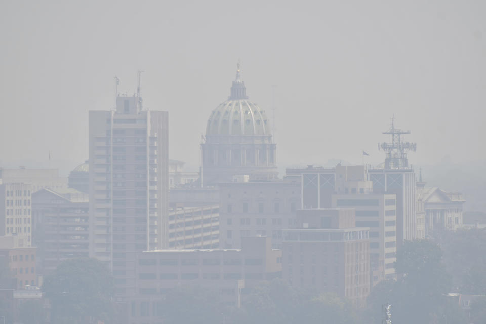 The Pennsylvania Capitol, seen from across the Susquehanna River, is shrouded in a haze from intense Canadian wildfires blanketing the northeastern U.S., prompting warnings for vulnerable populations to stay inside, Thursday, June 8, 2023, in Harrisburg, Pa. (AP Photo/Marc Levy)