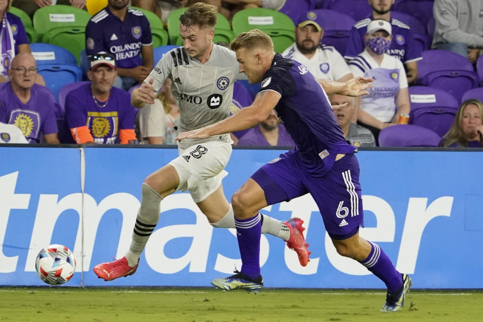 CF Montreal's Djordje Mihailovic, left, moves the ball past Orlando City's Robin Jansson (6) during the first half of an MLS soccer match, Wednesday, Oct. 20, 2021, in Orlando, Fla. (AP Photo/John Raoux)