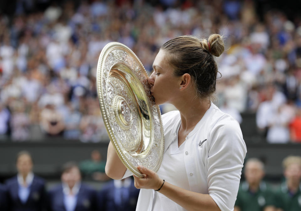 File - In this July 13, 2019, file photo, Romania's Simona Halep kisses the trophy after defeating United States' Serena Williams during the women's singles final match on day twelve of the Wimbledon Tennis Championships in London. Halep enters the U.S. Open ranked No. 4 as she comes off a championship at Wimbledon. (AP Photo/Kirsty Wigglesworth, File)