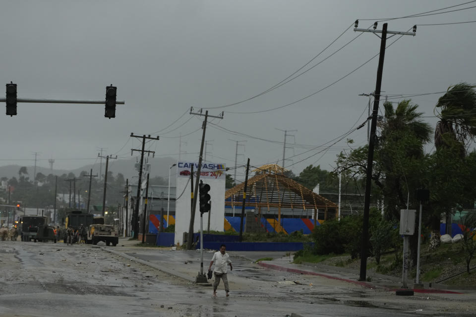 A man with his shoes off walks near an avenue flooded by the rains of Hurricane Norma in San Jose del Cabo, Mexico, Saturday, Oct. 21, 2023. Norma had weakened and was downgraded to Category 1 on the hurricane wind scale. It was located 25 miles west of Cabo San Lucas storm with winds of 85 mph (140 kmh) and expected to make landfall on Saturday, according to the U.S. (AP Photo/Fernando Llano)