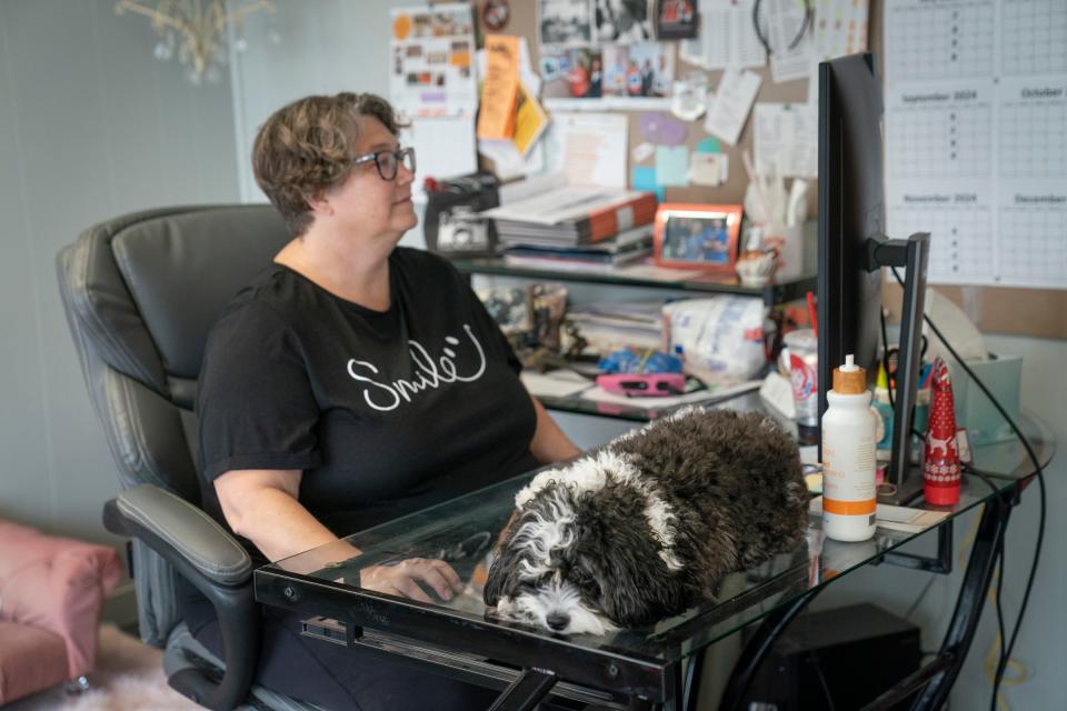 Winnie, a 2-year-old Cavapoo, lies on the desk of her owner Rachel Stiverson, 53, of Hudson, as she works at the Hudson Post-Gazette on Tuesday July 2, 2024.