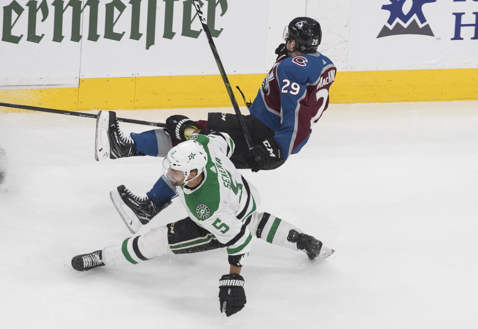 Colorado Avalanche center Nathan MacKinnon (29) is checked by Dallas Stars defenseman Andrej Sekera (5) during third-period NHL Western Conference Stanley Cup playoff hockey game action in Edmonton, Alberta, Saturday, Aug. 22, 2020. (Jason Franson/The Canadian Press via AP)