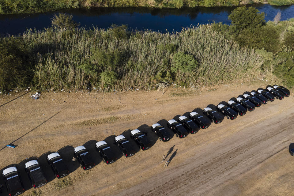 A line of Texas Department of Safety vehicles lines the bank of the Rio Grande near an encampment of migrants, many from Haiti, Wednesday, Sept. 22, 2021, in Del Rio, Texas. (AP Photo/Julio Cortez)