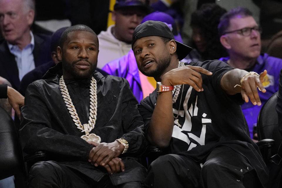 Boxer Floyd Mayweather Jr., left, talks with singer Usher during the first half of an NBA basketball game between the Los Angeles Lakers and the Oklahoma City Thunder Tuesday, Feb. 7, 2023, in Los Angeles. (AP Photo/Ashley Landis)